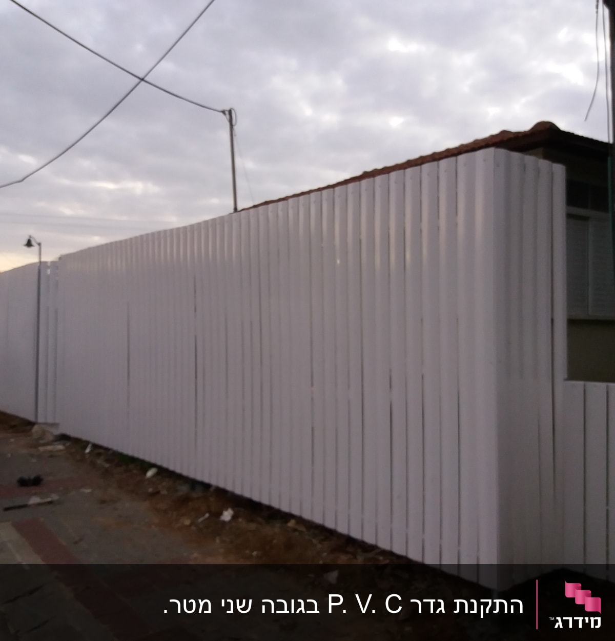 גדר לבנה גבוהה עשויה מלוחות עץ אנכיים